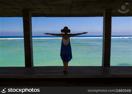 Beautiful woman with arms open on a beautiful tropical beach