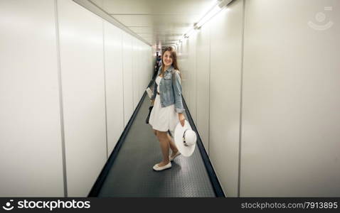 Beautiful woman with bags walking at boarding gate at airport