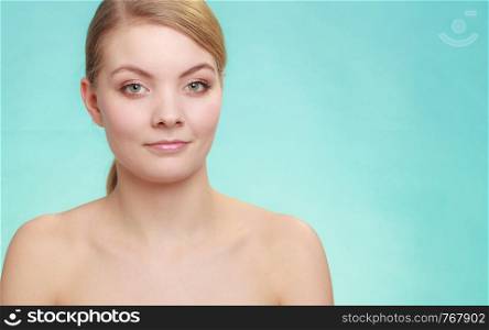 Beautiful woman with bare shoulders. Attractive girl with perfect clean skin. Studio shon on blue green background. Beautiful woman with bare shoulders