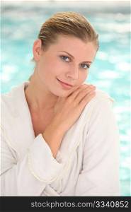 Beautiful woman with bathrobe standing by spa pool