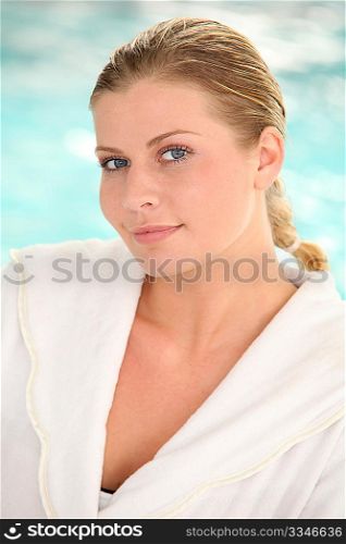 Beautiful woman with bathrobe standing by spa pool