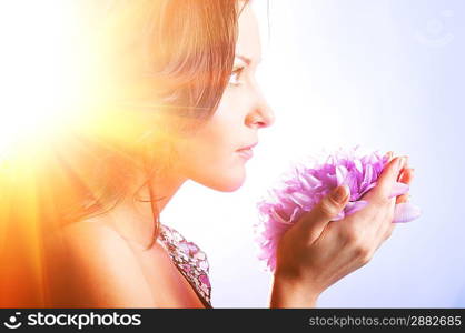 beautiful woman with big flower in sun rays