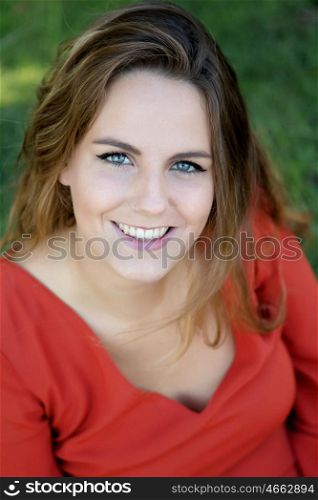 Beautiful woman with blue eyes dressed in red on a sunny day outside