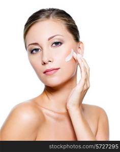 Beautiful woman with clean skin applying cosmetic cream on face