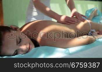 Beautiful woman with closed eyes relaxing outdoor at spa resort.