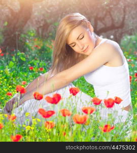 Beautiful woman with closed eyes sitting on poppy flower field, relaxation outdoors on fresh gentle floral meadow, enjoying spring nature&#xA;