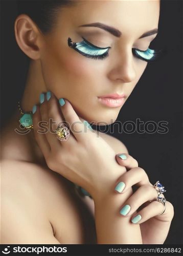 Beautiful woman with color eyelashes. Makeup and manicure. Jewelry.Closeup
