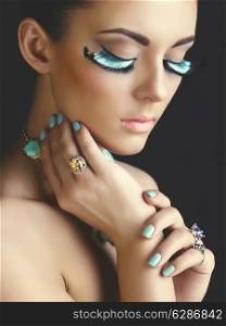 Beautiful woman with color eyelashes. Makeup and manicure. Jewelry.Closeup