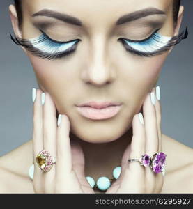 Beautiful woman with color eyelashes. Makeup and manicure. Jewelry.Closeup