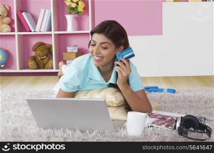 Beautiful woman with credit card shopping online at home