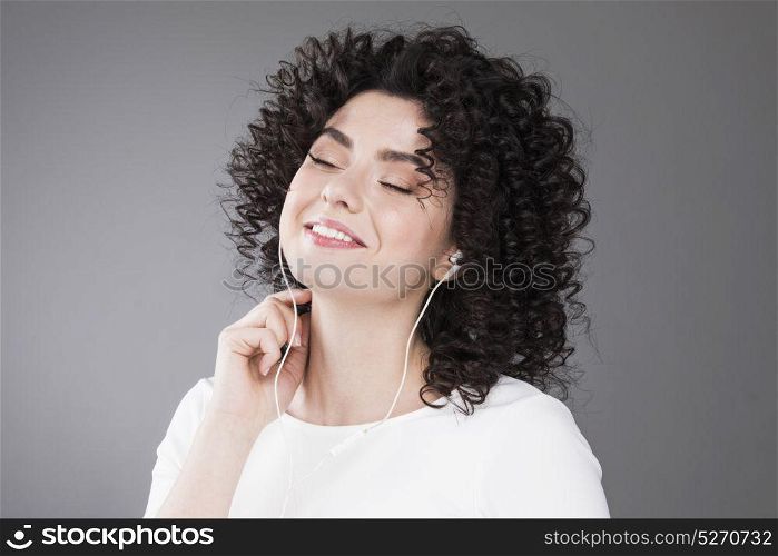 Beautiful woman with curly hair. Portrait of beautiful smiling woman with curly hair, gray background