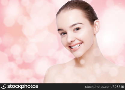 Beautiful woman with cute smile natural makeup spa skin care portrait on pink bokeh background