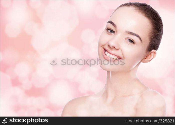Beautiful woman with cute smile natural makeup spa skin care portrait on pink bokeh background