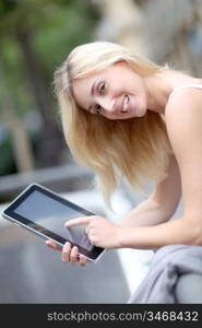 Beautiful woman with electronic tablet in town