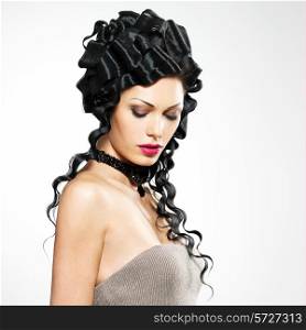 Beautiful woman with fashoin style curly hairstyle poses at studio