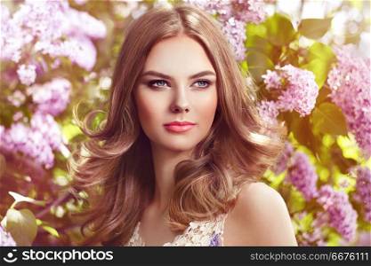 Beautiful woman with flowers of lilac. Beautiful Woman with Flowers of Lilac. Spring Blossom. Sexy Glamour Summer Beautiful Lady with Healthy and Beauty Hair