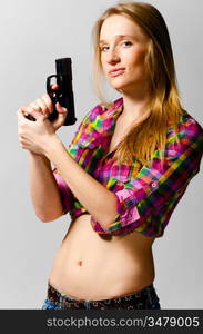 beautiful woman with gun on gray background