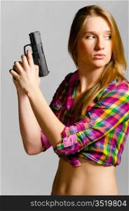 beautiful woman with gun on gray background