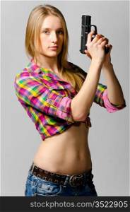 beautiful woman with gun on gray background