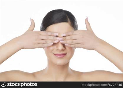 Beautiful woman with hands covering eyes