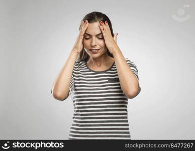 Beautiful woman with hands on head felling a headache