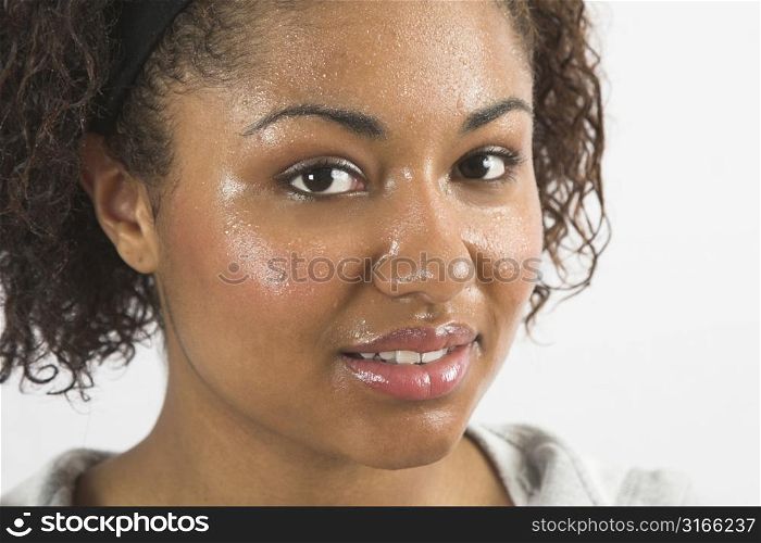 Beautiful woman with her face covered in sweat after working out