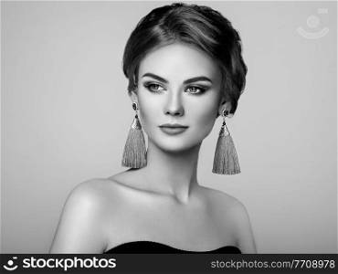Beautiful Woman with Large Earrings Tassels jewelry. Perfect Makeup and Elegant Hairstyle. Make-up Arrows