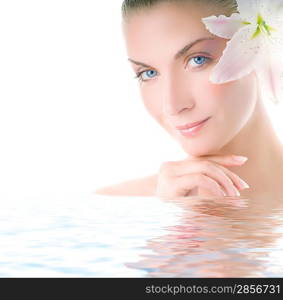 Beautiful woman with lily flower in her hair reflected in water