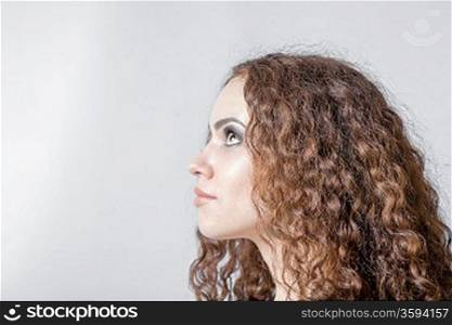 Beautiful woman with long curly hair head and shoulders in profile hairdo concept