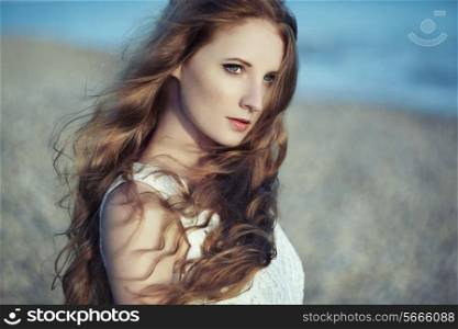 Beautiful woman with red hair at the sea. Fashiob photo