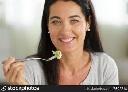 beautiful woman with salad on interior background