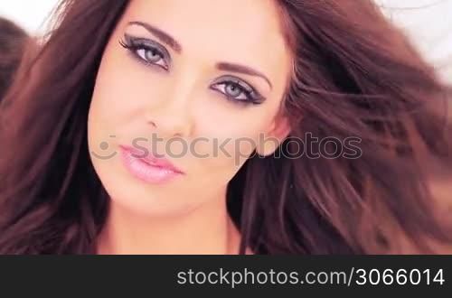 Beautiful woman with sultry eyes and a sensual expression wearing sexy makeup looking directlty into the camera