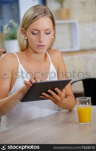 beautiful woman with tablet and juice in cafe