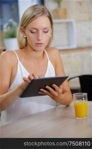 beautiful woman with tablet and juice in cafe