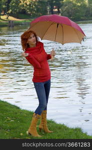 beautiful woman with umbrella looking up the sky if stop raining