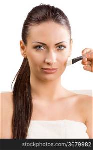 beautiful woman with white towel getting a beauty treatment with brush on face