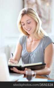 Beautiful woman working at home on agenda