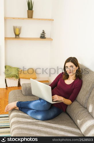 Beautiful woman working from the confort of home with her laptop