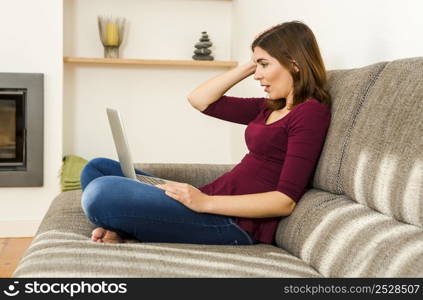 Beautiful woman working from the confort of home with her laptop