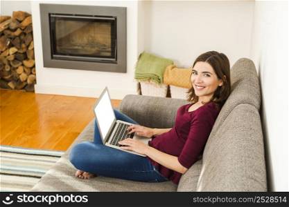 Beautiful woman working from the confort of home with her laptop