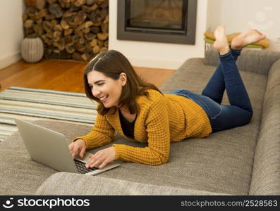 Beautiful woman working from the confort of home with her laptop