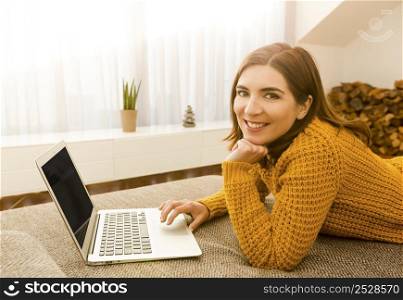 Beautiful woman working from the confort of home with her laptop