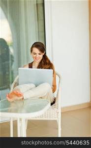 Beautiful woman working on laptop on vacation