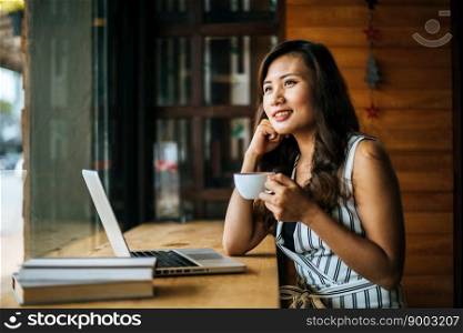 Beautiful woman working with laptop computer at coffee shop cafe