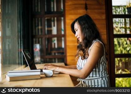 Beautiful woman working with laptop computer at coffee shop cafe