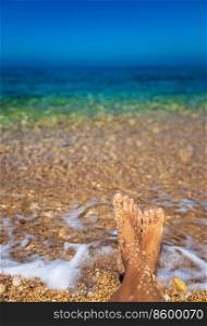 Beautiful Women Legs on the Beach in Clear Sea Water. Amazing Seascape. Relaxation on Seashore. Bright Sunny Day. Summer Vacation Concept. Wanderlust. Summer Holidays Concept