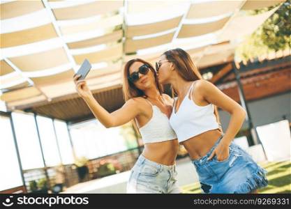 Beautiful women taking selfie by the pool at hot summer day