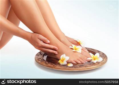 Beautiful womens legs and frangipani flowers over isolated background, beauty treatment, perfect skin waxing, pedicure in spa salon