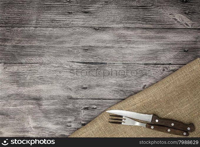Beautiful wooden background with napkin knife and fork. Fine background for the menu of restaurants and cafes. Beautiful wooden background with napkin knife and fork. Fine background for the menu of restaurants and cafes.