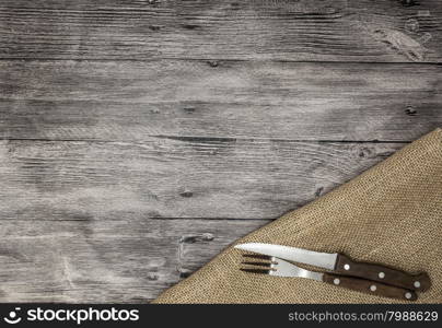 Beautiful wooden background with napkin knife and fork. Fine background for the menu of restaurants and cafes. Beautiful wooden background with napkin knife and fork. Fine background for the menu of restaurants and cafes.